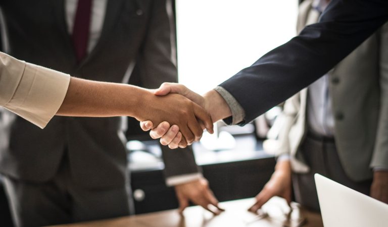 Business handshake. Two professionals in suits shaking hands, symbolizing partnership, agreement, and successful collaboration.